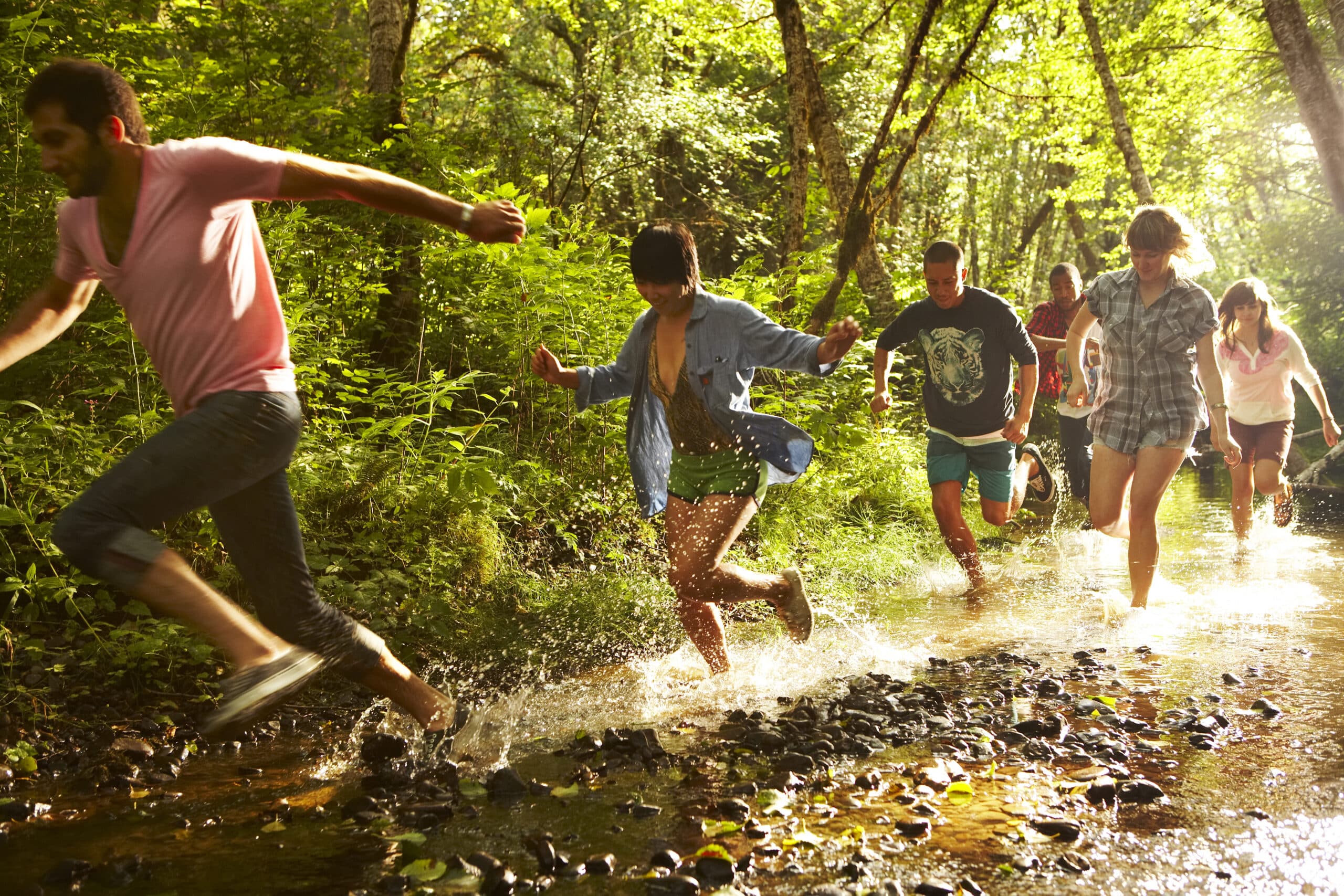 Group of friends running through stream